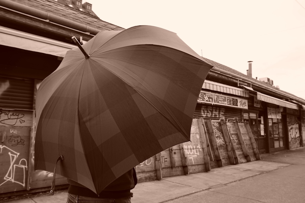 Foto einer Person, die einen großen aufgespannten Regenschirm hält